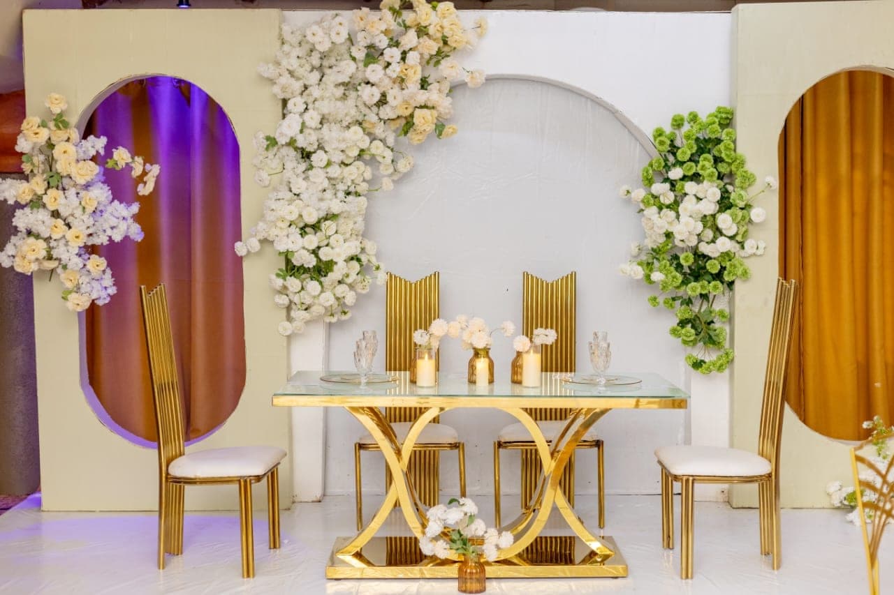 Arched backdrop in white and gold dressed with florals